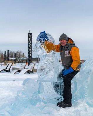 Sculptor Lee Ross posing with an ice sea lion in Canada 150 Square