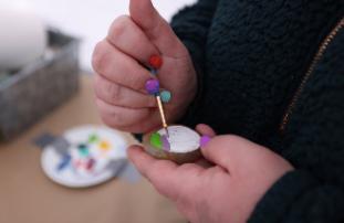 Artist painting an Easter egg onto a rock